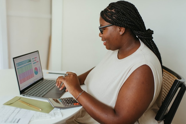 An analyst working through figures on her laptop