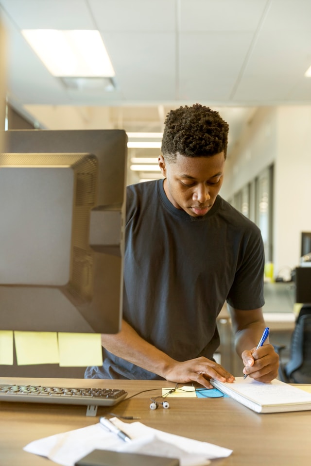 A developer taking notes at his desk