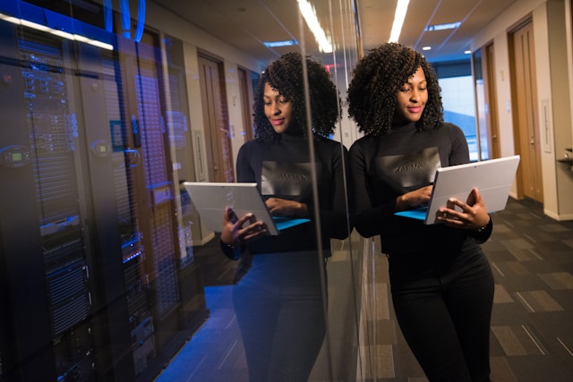 Two colleagues working on tablets in a server room